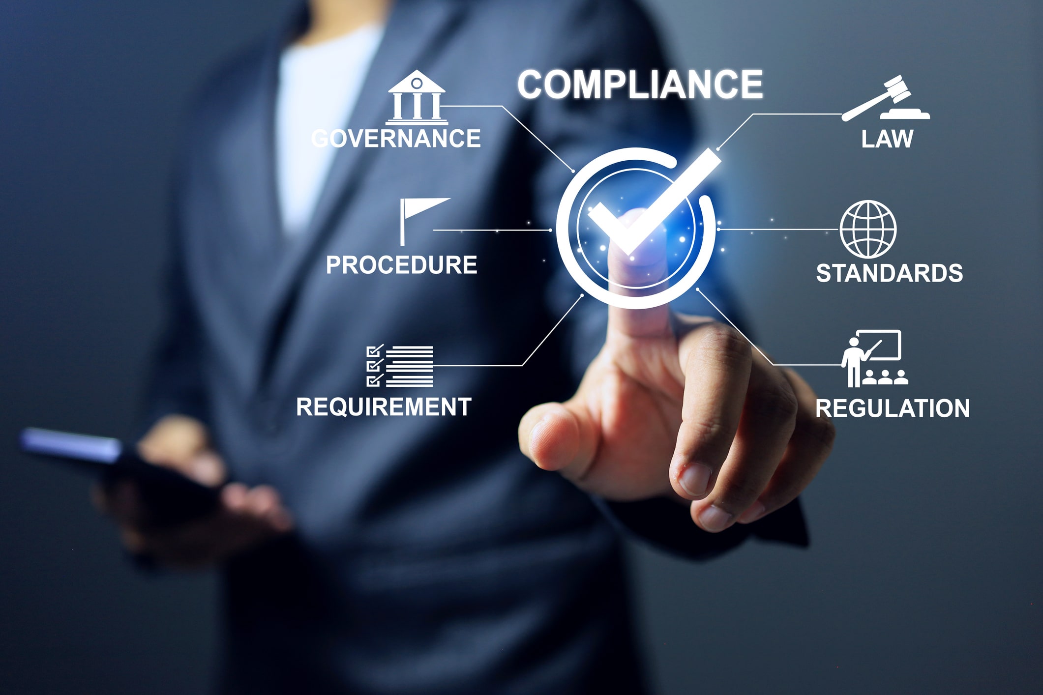 A man in a dark suit reaching towards a glowing tick inside a circle, with lines running out to icons labelled governance, law, procedure, standards, requirement and regulation